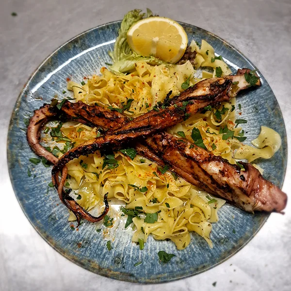 Kalimari mit Nudeln dekoriert mit Zitrone