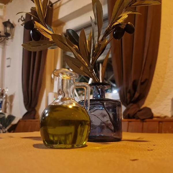 Dekorierter Tisch mit Olivenzweig und Olivenöl